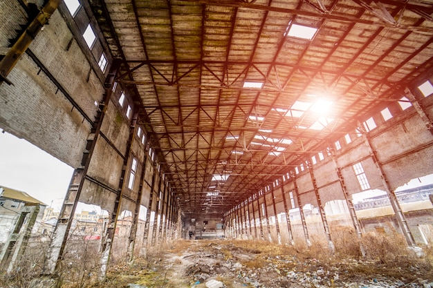 Binnenland van de oude fabrieksbouw vernietigd met gaten in dak en muren.