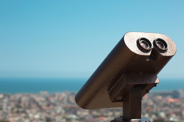 Binoculars from a height on the observation deck view of the\
panorama of the city and the sea sightseeing tour