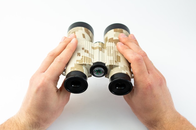 Binoculars in hands on a white background