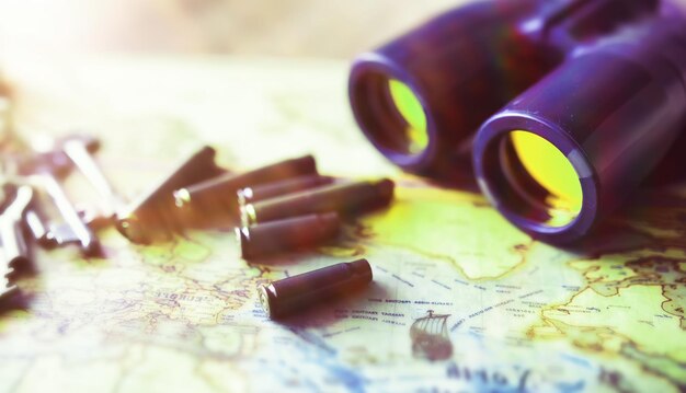 Binoculars and map on wooden table Top view traveler essentials concept