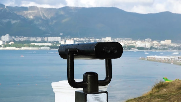 Photo binoculars on observation deck on background of sea concept black modern binoculars for viewing