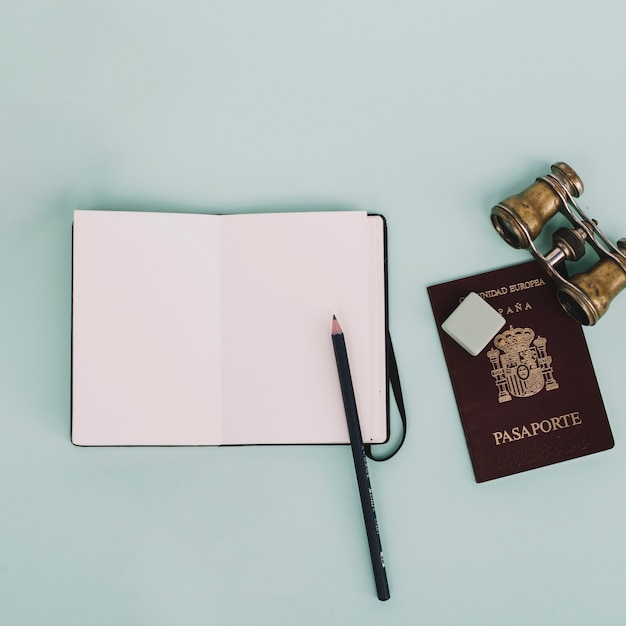 Binoculars and passport near notebook