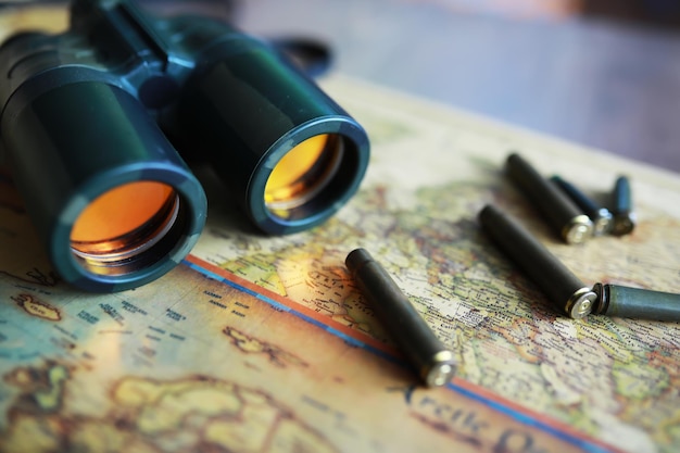 Photo binoculars and reflection in lenses map and shells background