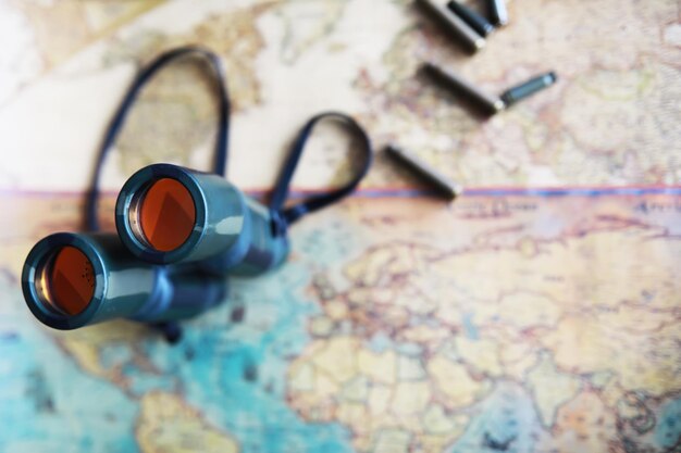 Binoculars and reflection in lenses Map and shells background