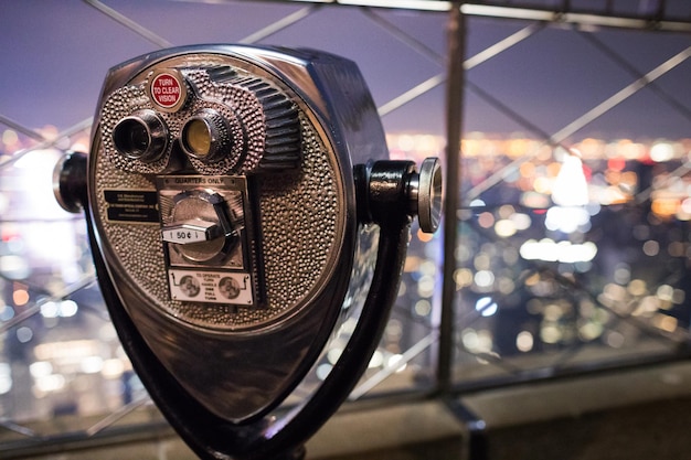 Binoculars on top of empire state building at night in manhattan new york