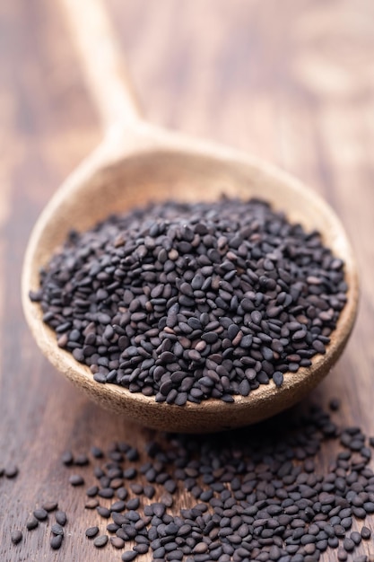 Bio natural black sesame seeds on wooden spoon