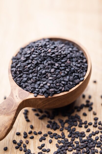 Bio natural black sesame seeds on wooden spoon