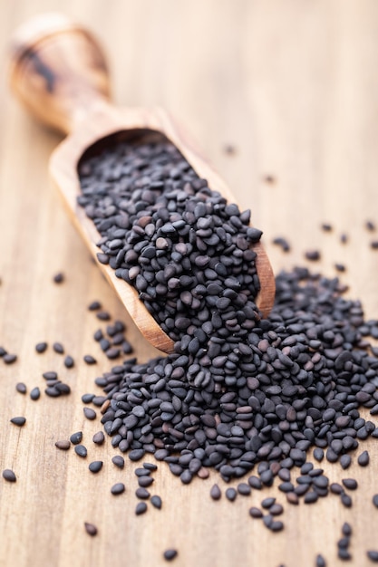 Bio natural black sesame seeds on wooden spoon