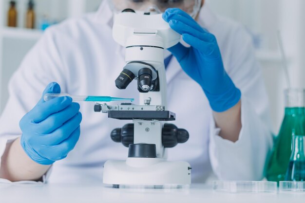Biochemisch onderzoeksteam dat werkt met een microscoop voor de ontwikkeling van coronavirusvaccins in de selectieve focus van farmaceutisch onderzoek in laboratoria