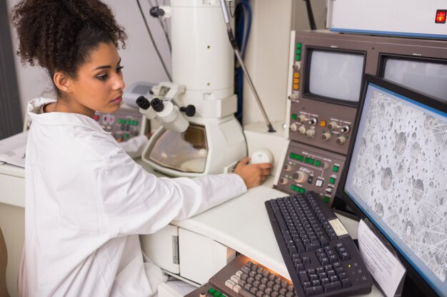 Biochemistry student using large microscope and computer