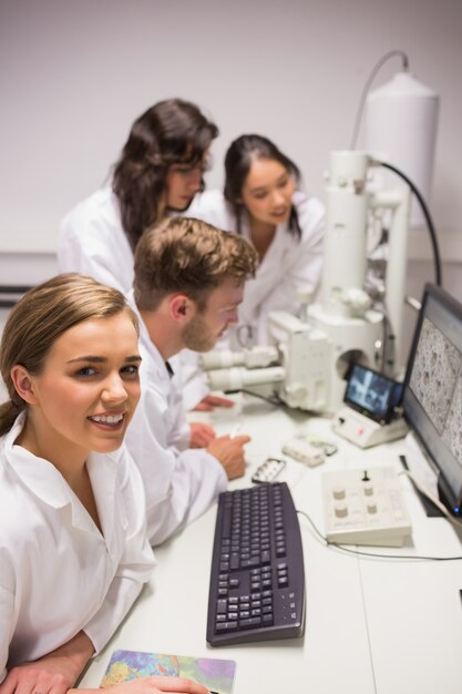 Biochemistry students using large microscope and computer