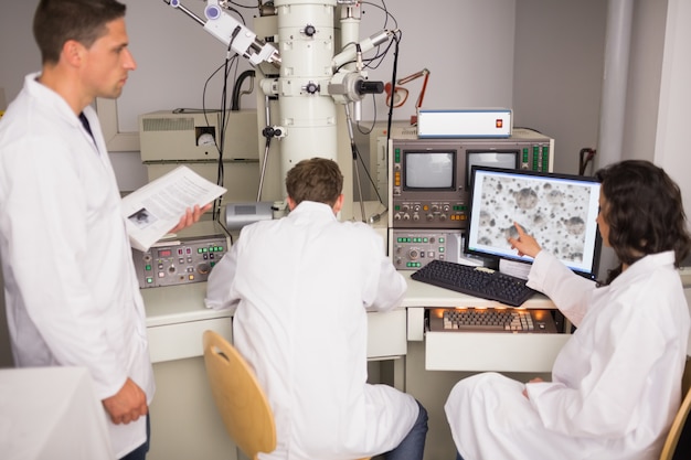 Biochemistry students using large microscope and computer