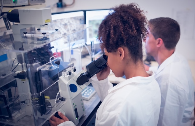 Biochemistry students using large microscope and computer