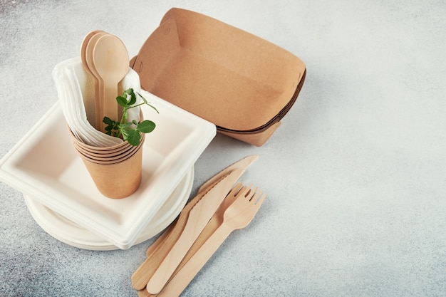 생분해성 일회용 식기. 종이 접시, 컵, 상자. 나무 칼.
