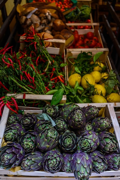 Foto carciofo biologico coltivato naturale, su un bancone del mercato. verdure dal mercato degli agricoltori. prodotti ecologici.