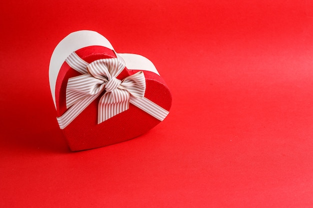Biologisch afbreekbare kartonnen geschenkdoos in de vorm van een hart met linten op rood