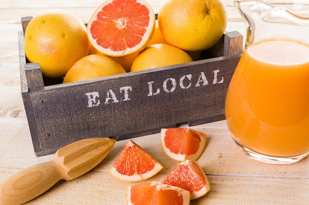 Biologisch robijnrood grapefruitsap in klein glas met ijs.