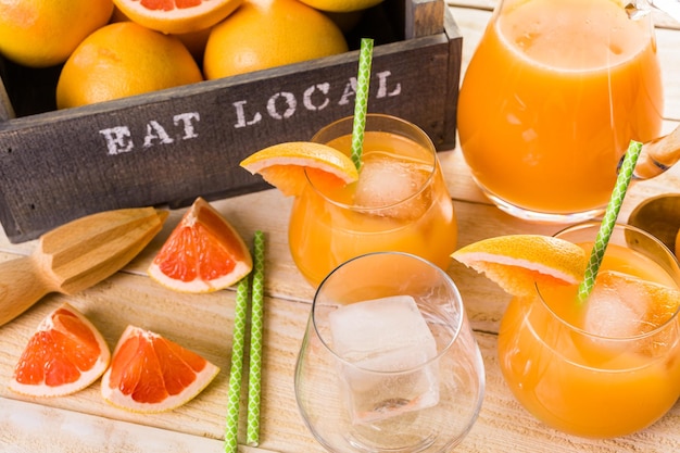 Biologisch robijnrood grapefruitsap in klein glas met ijs.