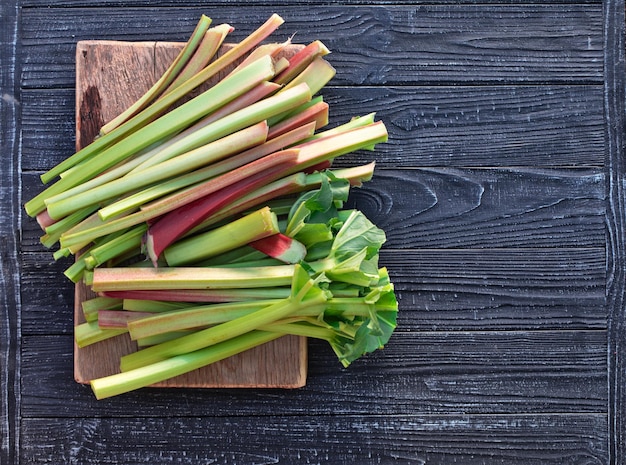 Biologisch vegetarisch eten Verse rabarberstekken op een houten tafel