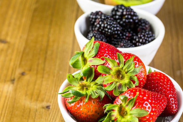 Biologisch vers fruit in ronde kommen op houten tafel.