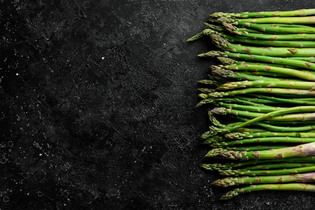 Biologisch voedsel Groene asperges op een zwarte stenen tafel Op een stenen achtergrond Bovenaanzicht