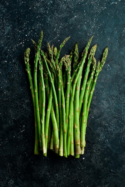 Biologisch voedsel Groene asperges op een zwarte stenen tafel Op een stenen achtergrond Bovenaanzicht