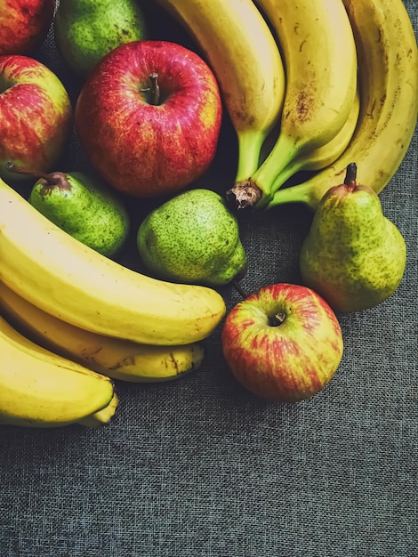 Biologische appels, peren en bananen op rustieke linnen achtergrond