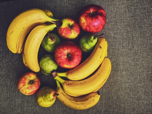 Biologische appels, peren en bananen op rustieke linnen achtergrond