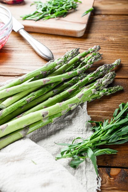 Biologische asperge-eieren en Franse dressingingrediënten met dijon-mosterd, ui gehakt in rode azijn taragon op lichte houten oude achtergrond, zijaanzicht verticaal.