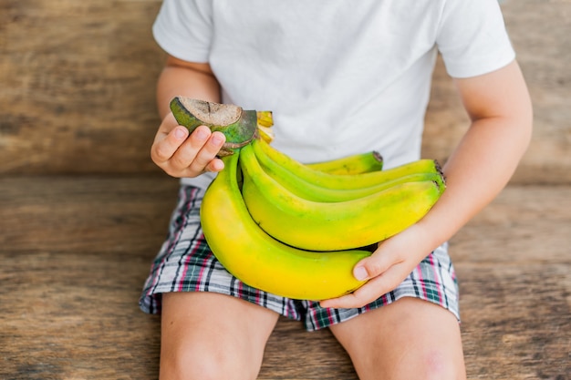 Biologische banaan in handen op de oude houten achtergrond