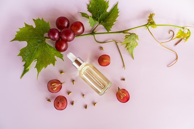 Biologische cosmetica olie gezichtsserum op basis van druivenpitolie biologische bio cosmetica vitaminen roze achtergrond bovenaanzicht