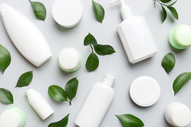 Biologische cosmetische producten met groene bladeren op kleur achtergrond