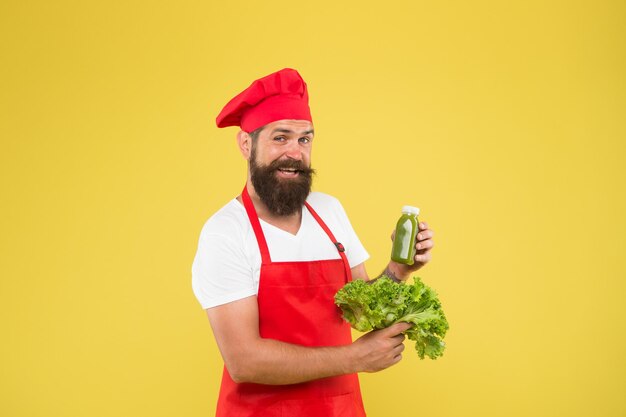 Biologische eco-veganistische producten bebaarde man chef-kok in schort en hoed hipster beslissen wat te kiezen gezond eten en diëten concept kok houd verse salade en smoothie in fles Calorie en dieet