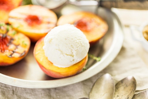 Biologische gegrilde perziken met bolletje vanille-ijs.