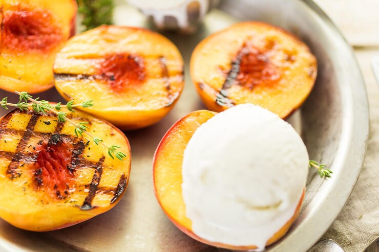 Biologische gegrilde perziken met bolletje vanille-ijs.