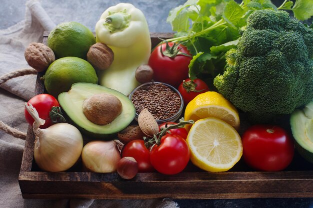 Biologische groenten, fruit, kruiden, noten, zaden in houten kist voor een gezonde levensstijl, rauw veganistisch dieet, selectieve focus