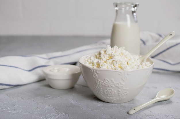 Biologische landbouw Kwark, gestremde melk in een witte keramische kom, zure room en melk in een fles