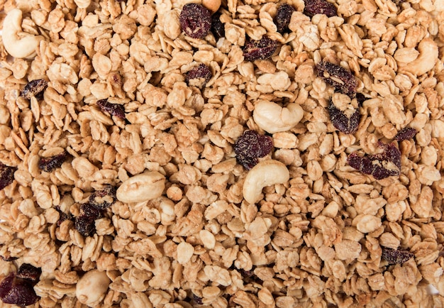 Foto biologische muesli met noten, cranberry en rozijnen geïsoleerd op wit.