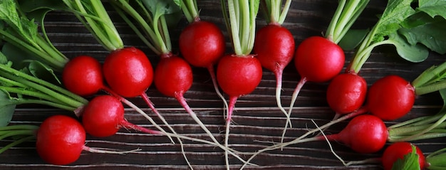 Biologische radijzen op een houten tafelblad bekijken Voedselbanner veganistisch eten achtergrond Het concept van lekker en gezond eten