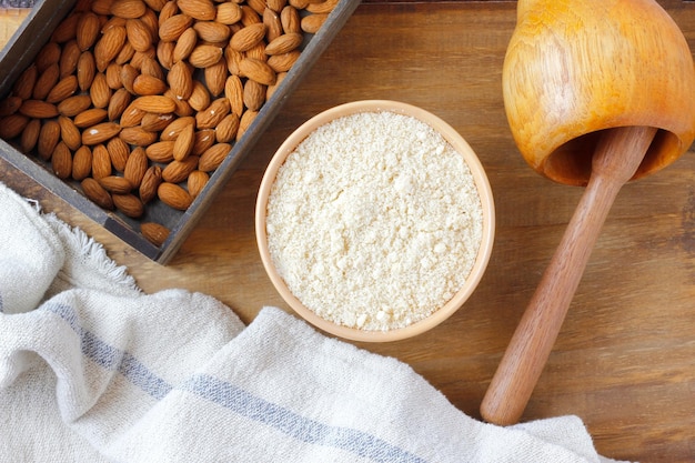 Biologische rauwe amandelmeel in kom over rustieke houten tafel glutenvrij eten