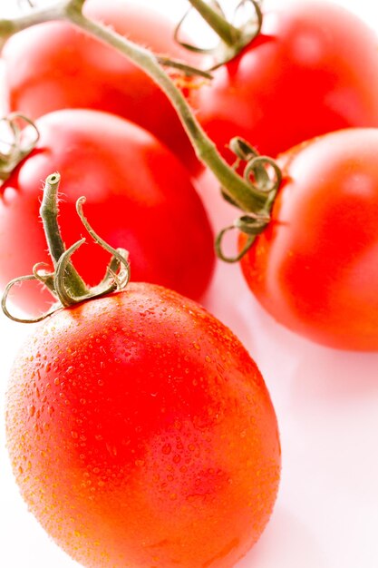 Biologische roma-tomaten op witte achtergrond.