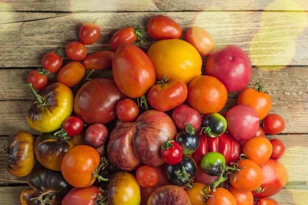 Biologische tomaten op een houten achtergrond Geassorteerde tomaten achtergrond