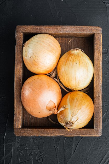 Biologische uien, op zwarte tafel, bovenaanzicht plat lag