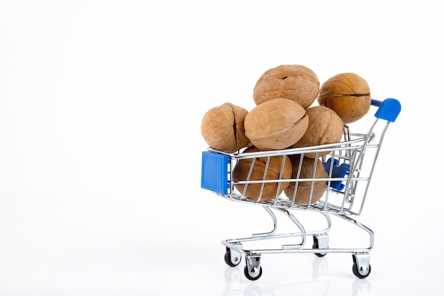 Biologische vers geoogste walnoten in schelpen in trolley van supermarkt op wit