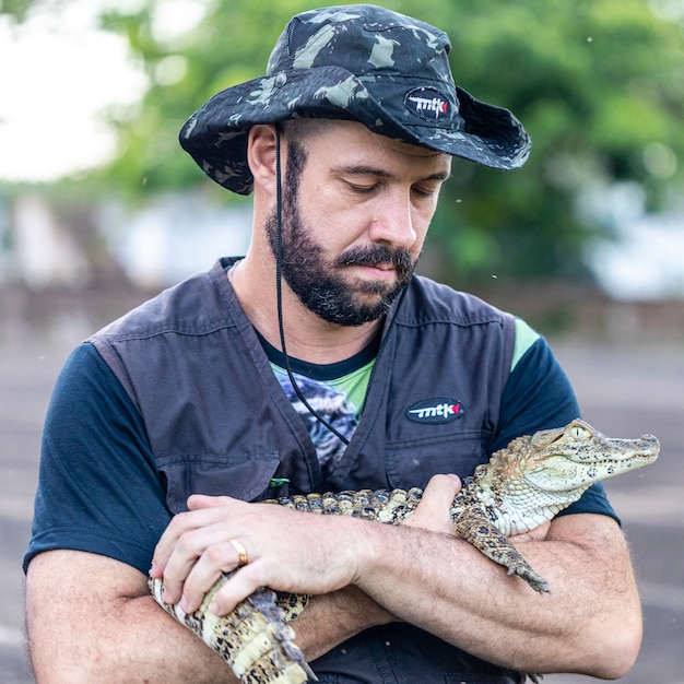 Biologist holding a alligator (Caiman latirostris) rescued with a broken paw