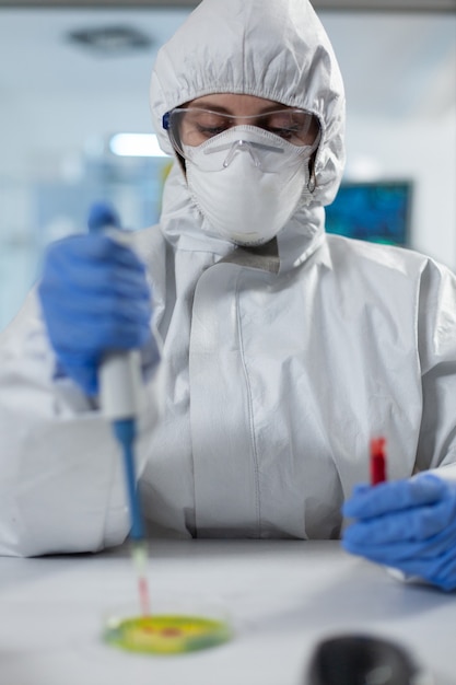 Biologist researcher woman hands putting blood in petri dish