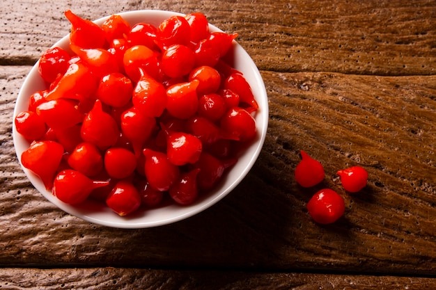 Перец Бихиньо в миску. Capsicum Chinense на деревянном столе.