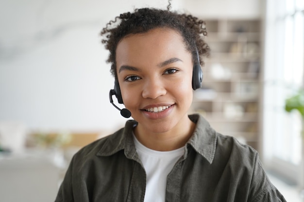 Biracial girl student in headset learning online looking at camera Distance education elearning