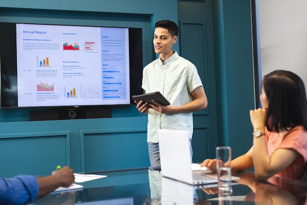 Photo biracial man presenting to diverse colleagues in a modern business office