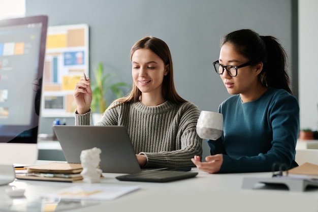 Biracial meisjes bespreken zakelijk project op het werk in het kantoor